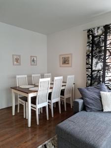 Un comedor con una mesa y sillas y un sofá. en Elice Apartment, en Rovaniemi