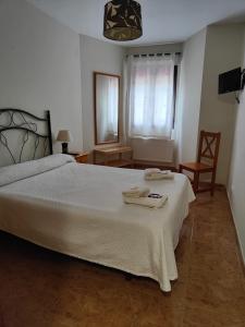 a bedroom with a large white bed and a chair at Hotel la Hoja*** in Aldeadávila de la Ribera