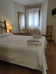 a bedroom with a white bed with two towels on it at Hotel la Hoja*** in Aldeadávila de la Ribera