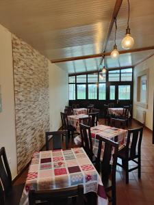 un ristorante con tavoli e sedie e un muro di mattoni di Hotel la Hoja*** a Aldeadávila de la Ribera