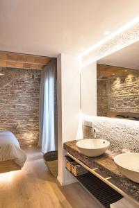 two sinks in a bedroom with a bed and a mirror at HomeSuiteHome Córdoba in Córdoba