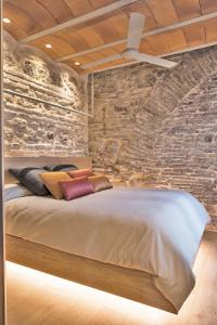 sypialnia z łóżkiem z kamienną ścianą w obiekcie HomeSuiteHome Córdoba w Kordobie