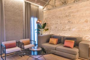 uma sala de estar com um sofá e duas cadeiras e uma mesa em HomeSuiteHome Córdoba em Córdoba