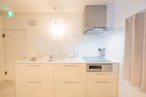 a kitchen with wooden cabinets and a sink at Furano Powder Chalet in Furano +19 photos