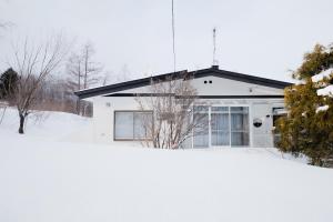 a house in the snow in front at Furano Powder Chalet in Furano
