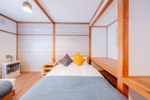 1 dormitorio con 1 cama con pared de madera en Furano Powder Chalet en Furano