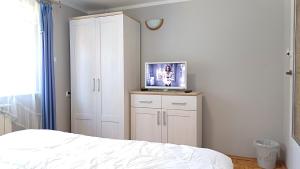 um quarto com uma cama e uma televisão num armário em Matylda House em Cracóvia