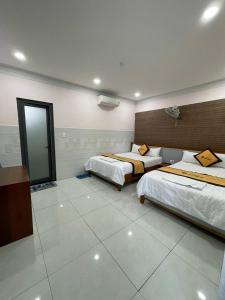 Ðông HòaにあるHương Thiên Phú Hotelのベッド2台と鏡が備わるホテルルームです。