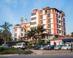 ein großes Gebäude mit Autos auf einem Parkplatz in der Unterkunft Hotel Kingdom in Mwanza