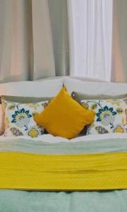 a bed with pillows and a yellow pillow on it at ST Apartment in Vienna