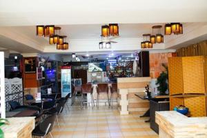 un restaurante con bar y algunas mesas y sillas en Hotel Kingdom en Mwanza