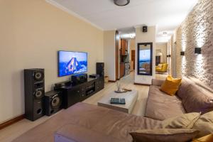 een woonkamer met een bank en een flatscreen-tv bij A luxurious and modern apartment in Midrand