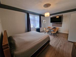 Schlafzimmer mit einem Bett und einem Tisch mit Stühlen in der Unterkunft Villa Hänsch Suite 2 in Großschönau