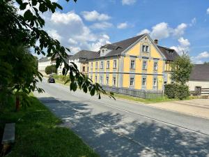un gran edificio amarillo en el lateral de una calle en Villa Hänsch Suite 2, en Großschönau