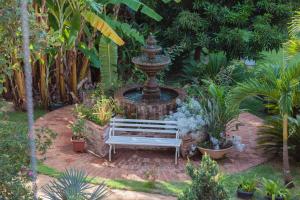 a fountain with a bench in a garden at Pousada Adega Cipo in Serra do Cipo