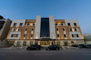 a large building with cars parked in front of it at Vivian Park El Raeid Hotel in Riyadh