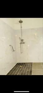 a bathroom with a shower with white marble walls at Hotel - Restaurant de la Paix in Barbotan-les-Thermes