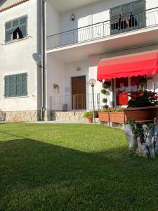 una casa con un toldo rojo en un patio en Appartamento L'Edera, en Santo Stefano di Magra