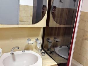 uma casa de banho com um lavatório, um espelho e uma banheira em Appartement Bormes-les-Mimosas, 2 pièces, 5 personnes - FR-1-610-54 em Bormes-les-Mimosas