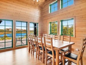 a dining room with a table and chairs and windows at Holiday home Tjørhom II in Tjørhom