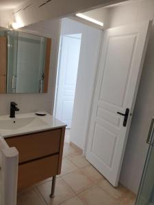 baño con lavabo y puerta blanca en Beau duplex lumineux sur jardin, en Cabriès