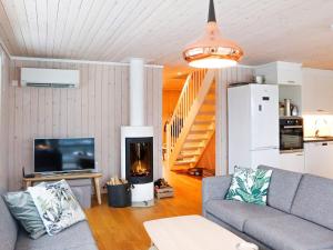 uma sala de estar com um sofá e uma lareira em Holiday home Risør em Risør