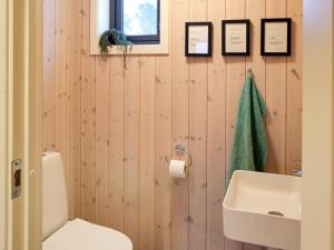 La salle de bains est pourvue de toilettes blanches et d'un lavabo. dans l'établissement Holiday home Risør, à Risør