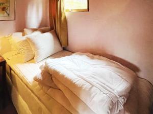 1 cama con sábanas blancas y almohadas en una habitación en Holiday home Ucklum IV, en Ucklum