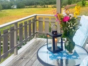 szklany stół z wazonem kwiatów i świecą w obiekcie Holiday home Melfjordbotn 