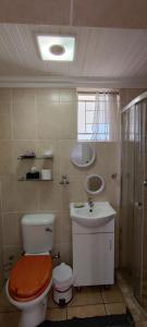 a bathroom with a toilet and a sink and a shower at Premiere Guesthouse in Bloemfontein
