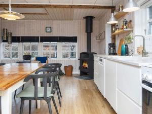 una cucina con tavolo in legno e piano cottura di Holiday home Grenaa XXXII a Grenå