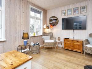 een woonkamer met een televisie aan een houten muur bij Holiday home Grenaa XXXII in Grenå