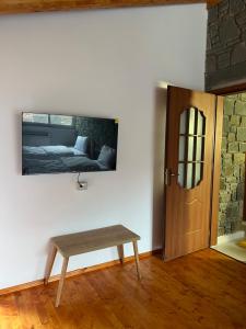 a room with a table and a tv on the wall at Xhaferri Guesthouse in Çorovodë