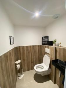 a bathroom with a toilet and a black counter at Appartement Le Cocoon in Le Cheylard