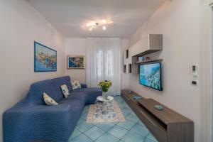 Maiori Apartment by Marcel في مايوري: غرفة معيشة مع أريكة زرقاء وطاولة