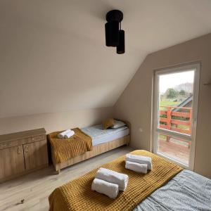 2 camas en una habitación con ventana en Domki Letniskowe Stokrotka en Pustkowo