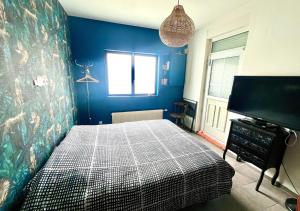 1 dormitorio con 1 cama y TV de pantalla plana en Chambre tropicale privée, en Liévin