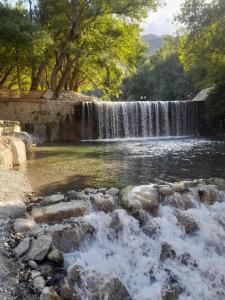 une cascade en face d'une rivière avec des rochers dans l'établissement Casa Rosanna, à Marina di Caulonia