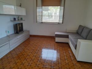 ein Wohnzimmer mit einem Sofa und einem TV in der Unterkunft Casa Rosanna in Caulonia Marina