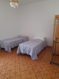 2 Betten nebeneinander in einem Zimmer in der Unterkunft Casa Rosanna in Caulonia Marina