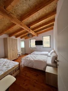 a large bedroom with two beds and wooden ceilings at Xhaferri Guesthouse in Çorovodë