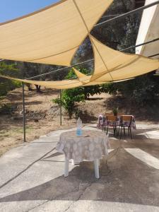 einen Tisch und einen großen gelben Regenschirm auf einer Terrasse in der Unterkunft Casa Rosanna in Caulonia Marina