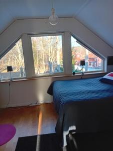 een slaapkamer met een bed en 2 grote ramen bij Exklusive villa on the coast close to Stockholm in Åkersberga +31 foto's