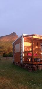 a tiny house on a pile of logs in a field at LA CABAÑA DEL CAMPO in Ushuaia