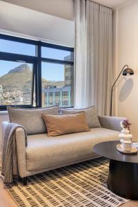a living room with a couch and a large window at Luxury Mountain View Aparthotel at The Tokyo- 12th Floor No Loadshedding in Cape Town
