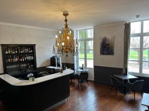 a bar with a chandelier and some tables and chairs at Château de La Barge in Chaintré