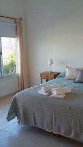 1 dormitorio con 1 cama con toallas en Posada Rojo Malbec en San Rafael