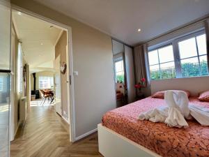 sypialnia z łóżkiem z różową pościelą i lustrem w obiekcie NEW - Private Residence - on a lake near Amsterdam w mieście Vinkeveen