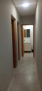 un corridoio di un bagno con lavandino e specchio di El Descanso a Ezeiza