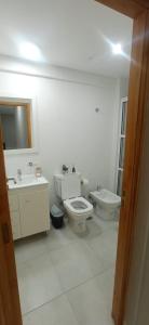 een witte badkamer met een toilet en een wastafel bij El Descanso in Ezeiza
